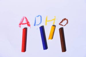 ADHD written on sheet of paper in different colored crayons