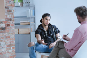 teenage boy with behavioral problems talking to a psychologist